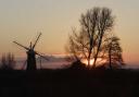 Norfolk at its alluring best with windmill, trees and moody skies combining for a sunset symphony