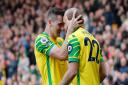 Norwich City striker Teemu Pukki take the congratulations from Kenny McLean after sealing a 2-0 Premier League win over Burnley