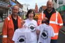 RSPCA charity shop manager Julie Spooner shows off her 'I've seen the Sheringham sinkhole' tee shirts to Public Sewer Services site manager Gavin Read (left) and Anglian Water supervisor James Dobie, who are working on repairing the sinkhole in High Stree