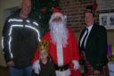 The tricker, Santa and drummer from Phoenix Band plus one of YoungEyes youngsters at the Christmas Glitter Party. Picture Dorothy Bowen
