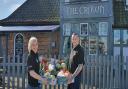 Trina Lake and Bradley Richards with their fruit and vegetable boxes outside The Crown pub in Costessey. Photo: Trina Lake