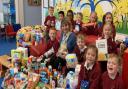 Headteacher of Cecil Gowing Infant School in Sprowston with pupils and the various food donations