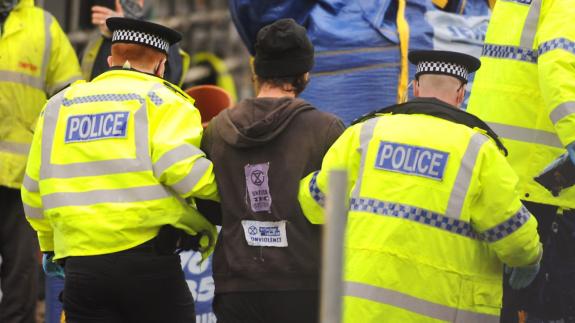 Norwich Evening News: Police arrest and handcuff protester Alex Sidney as he comes down from the crane in Duke Street. Picture: DENISE BRADLEY Norwich Evening News: Police arrest and handcuff protester Alex Sidney as he comes down from the crane in Duke Street. Picture: DENISE BRADLEY