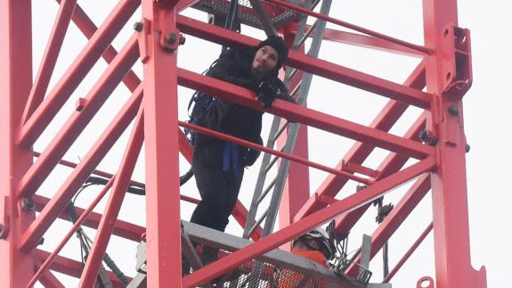 Norwich Evening News: Alex Sidney ends his protest and comes down the crane in Duke Street, with fire search and rescue crew. Picture: DENISE BRADLEY Norwich Evening News: Alex Sidney ends his protest and comes down the crane in Duke Street, with fire search and rescue crew. Picture: DENISE BRADLEY