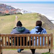 A couple enjoy the view of Sheringham from Beeston Bump.