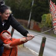 Three-year-old Cody Andrews battling with an umbrella with help from mum Leanna, as high winds hit Norfolk.