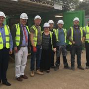 Hethel firm Beattie Passive opens its first flying factory at the Graven Hill development in Oxfordshire. Ron and Rosemary Beattie (far left and far right) with MP Richard Bacon, Graven Hill managing director Karen Curtin, and on-site workers. Picture: