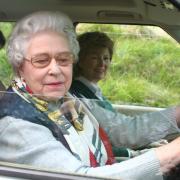 The Queen at the wheel having stopped to talk to the Sadd family during a holiday outing at Balmoral