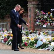 The Prince and Princess of Wales view flowers and tributes left at the Norwich gates at Sandringham in honour of the late Queen Elizabeth II