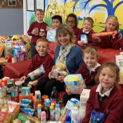 Headteacher of Cecil Gowing Infant School in Sprowston with pupils and the various food donations