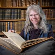 Norwich Cathedral's librarian, Gudrun Warren, is celebrating the 550th anniversary of the library's oldest book, Divine Institutes