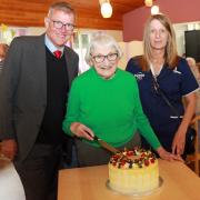 Harriet Court resident Ida Innes cuts the celebratory cake at the home 20 years after she laid the first brick